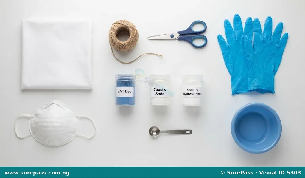 A collection of materials for tie and dye, including fabric, twine, scissors, safety gear, dye chemicals, and a basin.